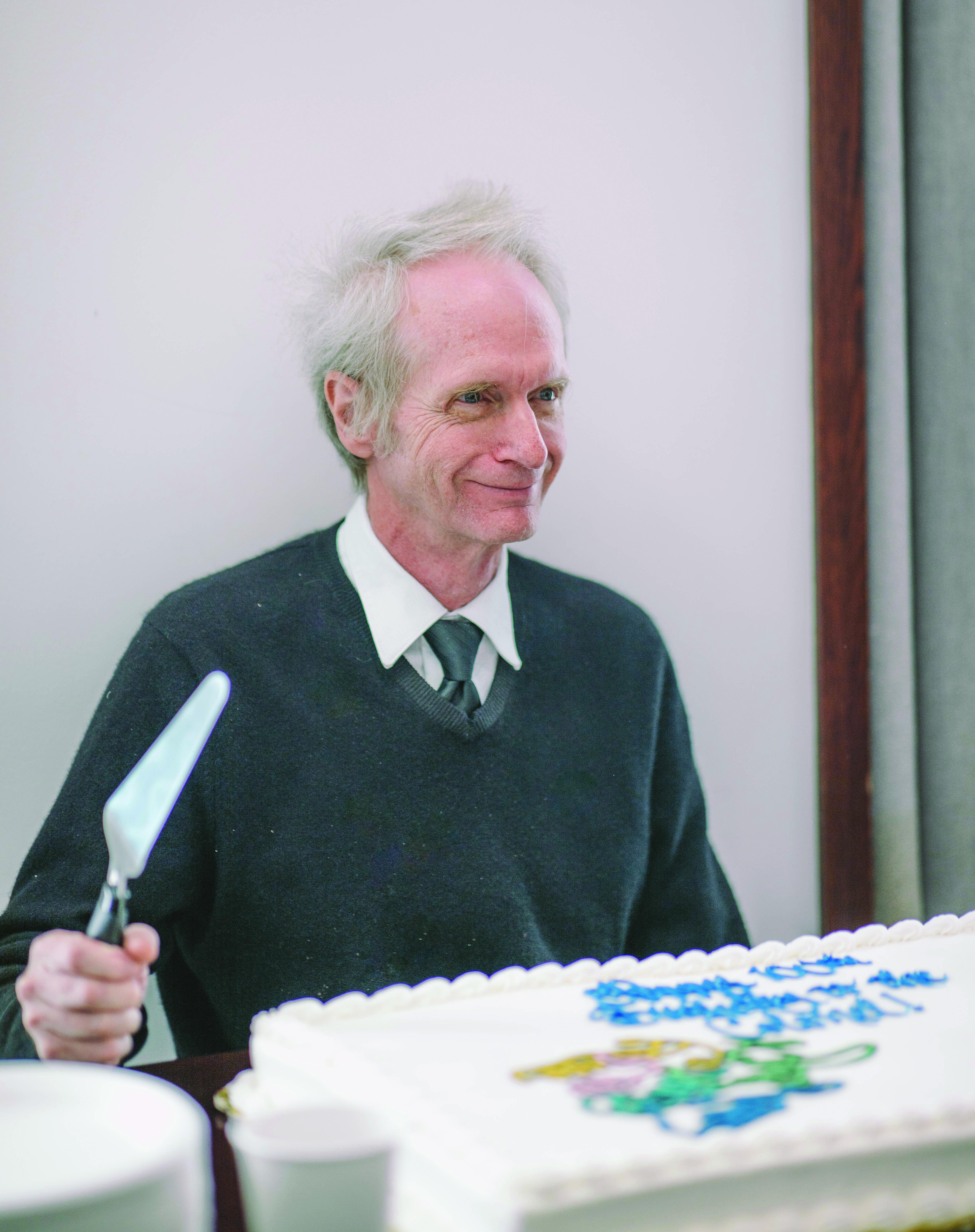 Dr. Lipscomb's son cuts a cake.